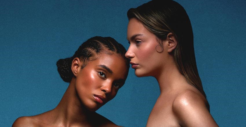 Two female models with hydrated skin post next to one another