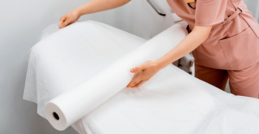 Couch roll being rolled onto a bed